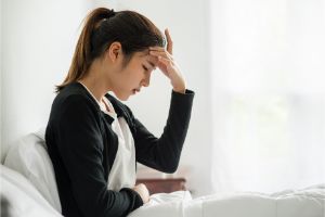 妊娠超初期の女性が頭痛に苦しんでいる